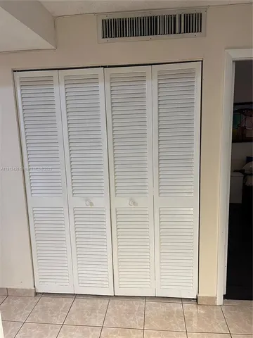 a view of a hallway with wooden floor and a livingroom