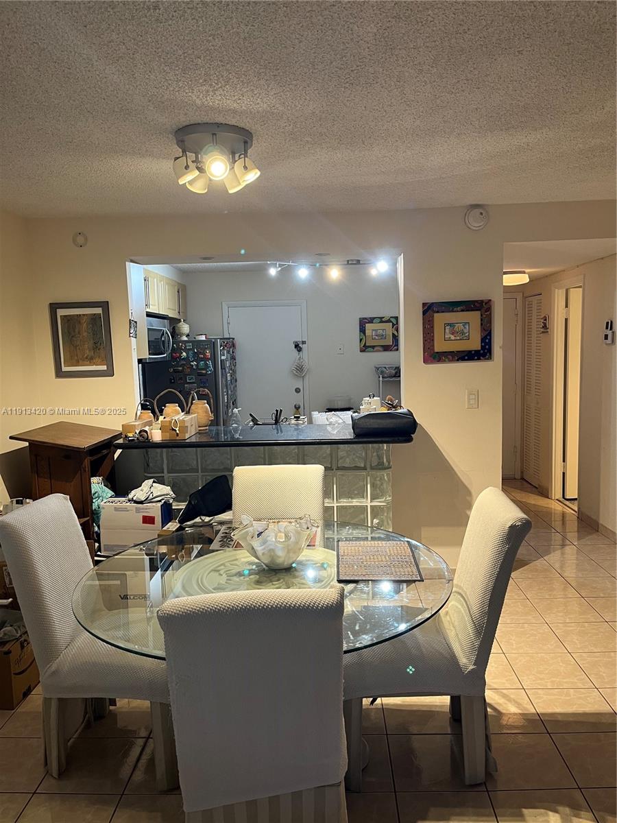 8233 Harding Avenue, Unit 305 Miami Beach, FL 33141 - Photo 41 of 46 a dining room with a table chairs and a kitchen view