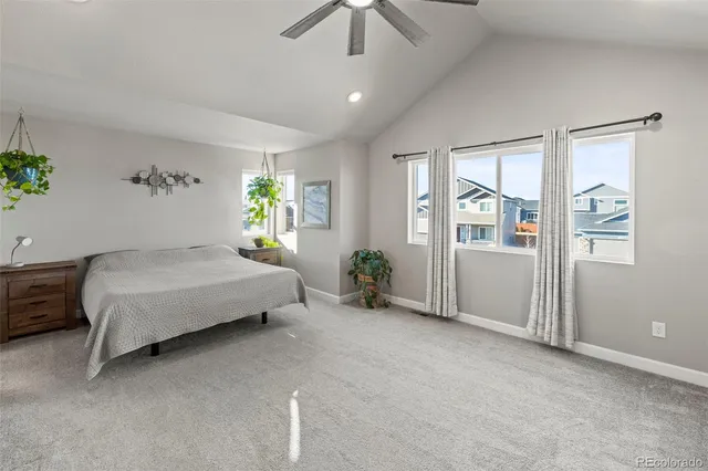 a bedroom with a large bed and a chandelier fan