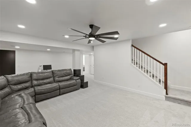 a living room with furniture and a ceiling fan