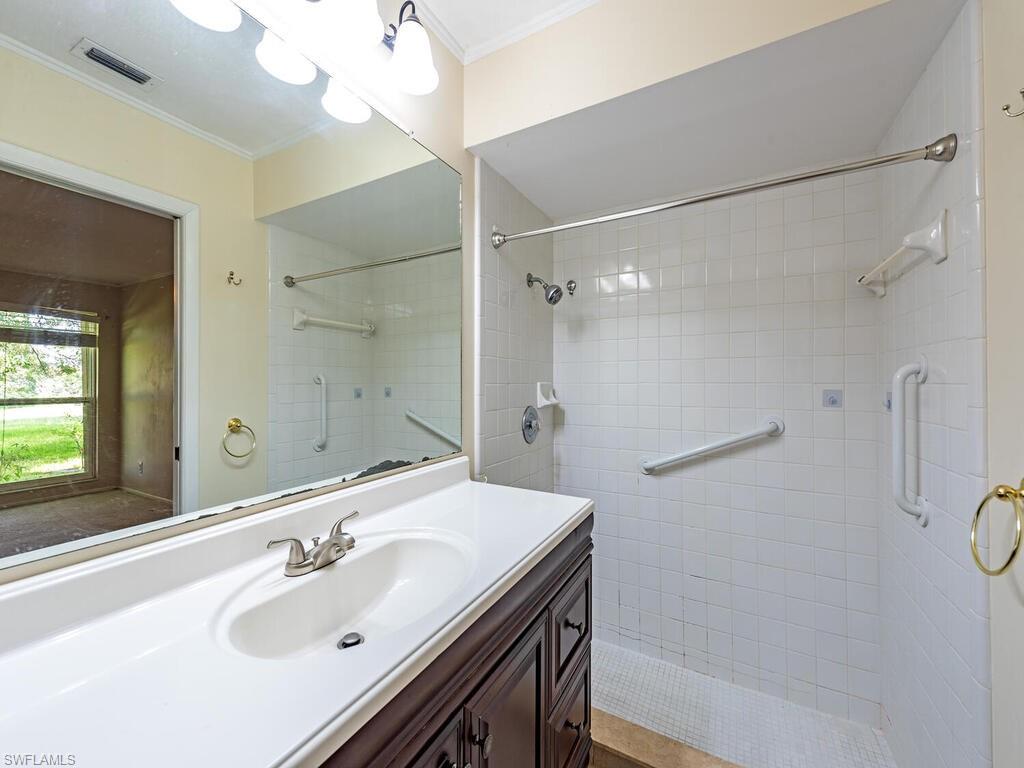 130 Round Key Circle, Unit G10 Naples, FL 34112 - Photo 8 of 12 a bathroom with a sink mirror and shower