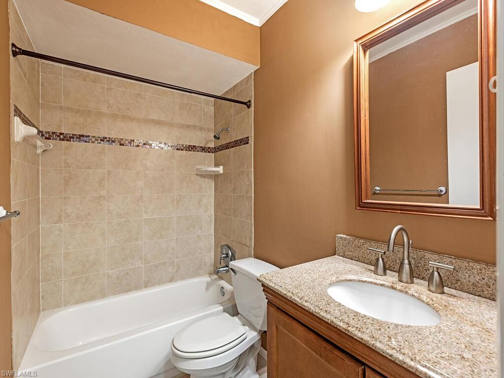 130 Round Key Circle, Unit G10 Naples, FL 34112 - Photo 10 of 12 a bathroom with a granite countertop sink mirror toilet and bathtub