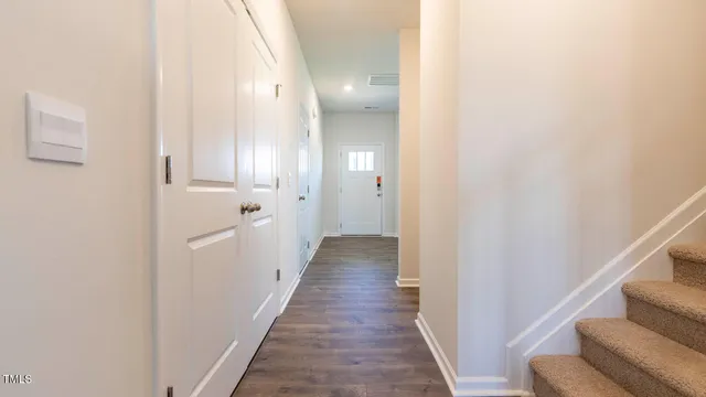 a view of a hallway with wooden floor and staircase