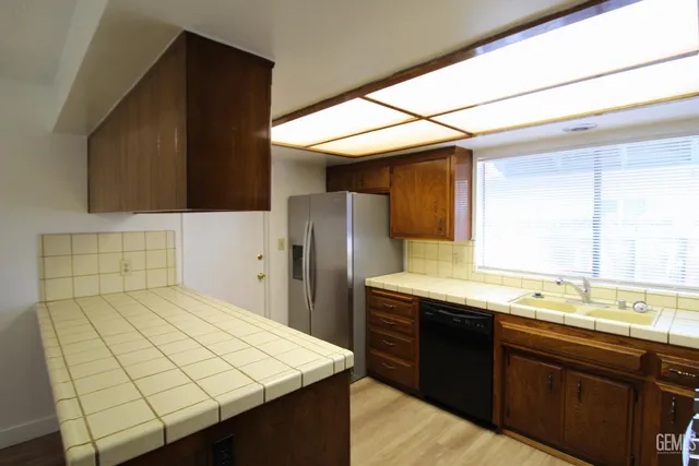 a kitchen with a sink refrigerator and cabinets
