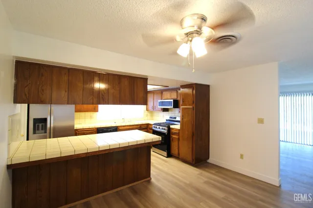 a kitchen with stainless steel appliances kitchen island granite countertop a refrigerator a sink and dishwasher