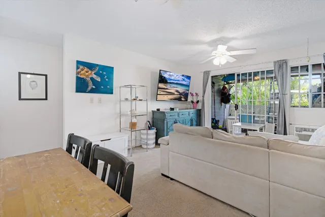 a living room with furniture a flat screen tv and a large window