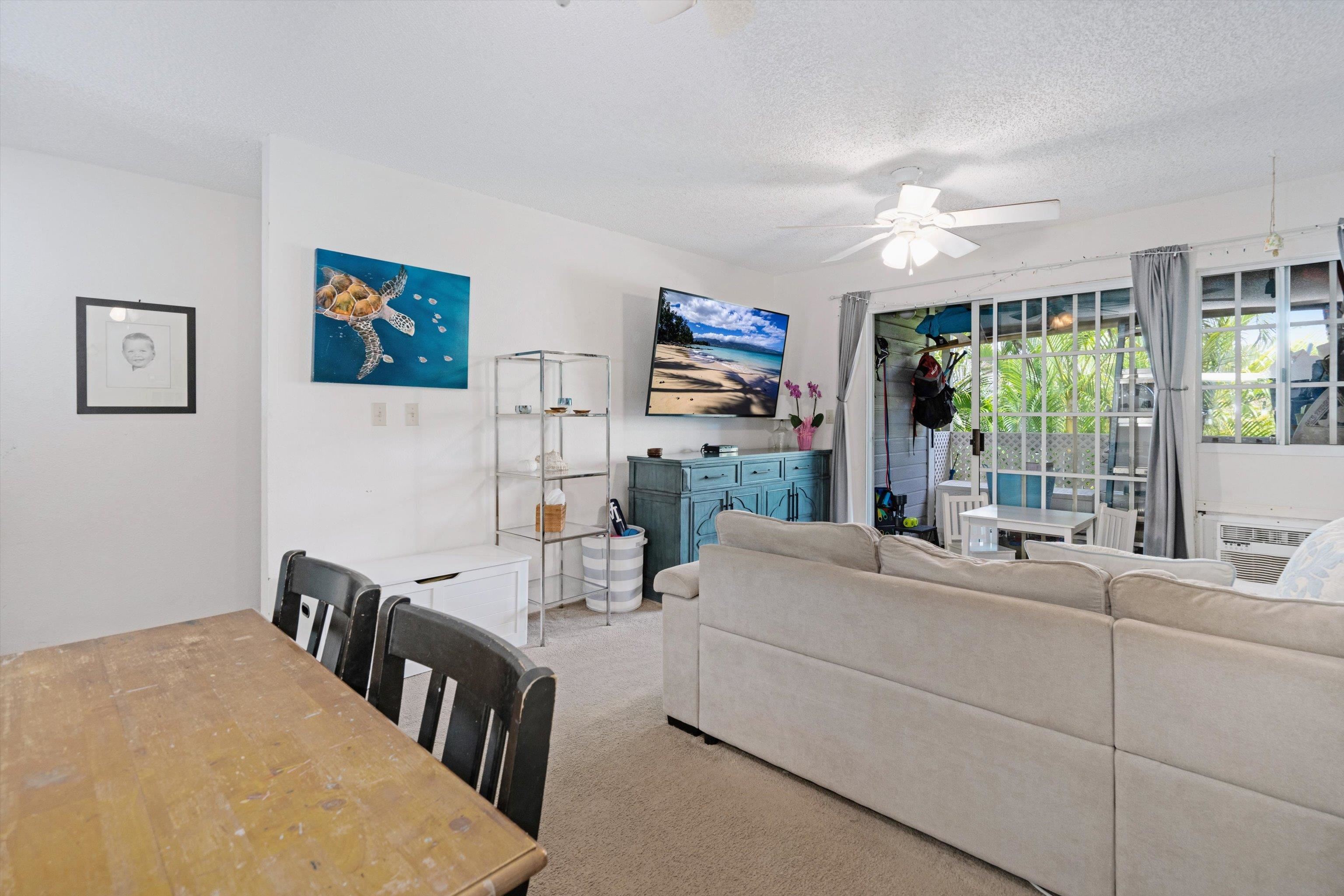 160 Keonekai Road, Unit 27201 Kihei, HI 96753 - Photo 17 of 29 a living room with furniture a flat screen tv and a large window