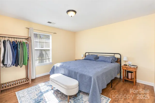 a bedroom with a bed and wooden floor