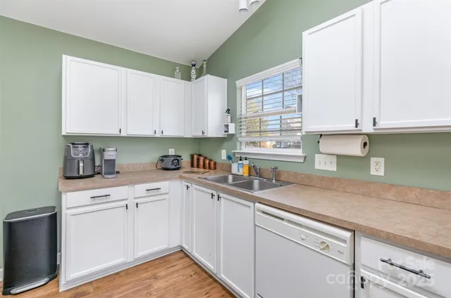 a kitchen with stainless steel appliances granite countertop a sink and cabinets with wooden floor