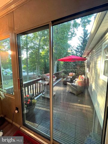 a view of a patio with table and chairs under an umbrella with a small yard
