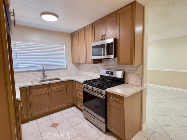711 North Soldano Avenue, Unit 6 Azusa, CA 91702 - Photo 11 of 41 a kitchen with stainless steel appliances granite countertop a sink stove and microwave