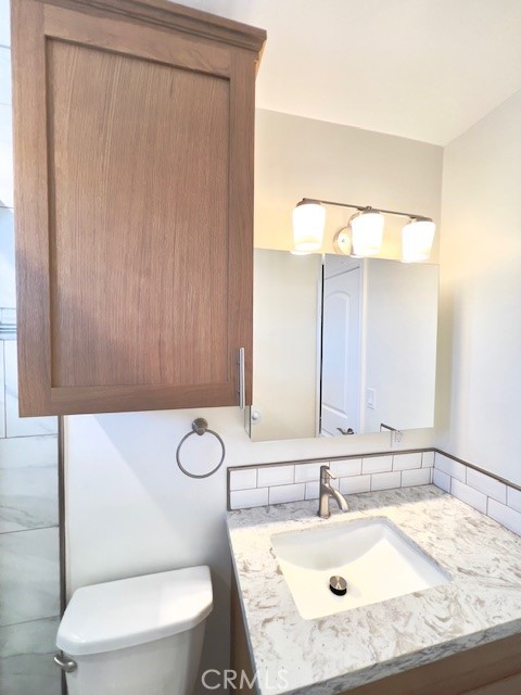 711 North Soldano Avenue, Unit 6 Azusa, CA 91702 - Photo 35 of 41 a bathroom with a toilet sink vanity and mirror
