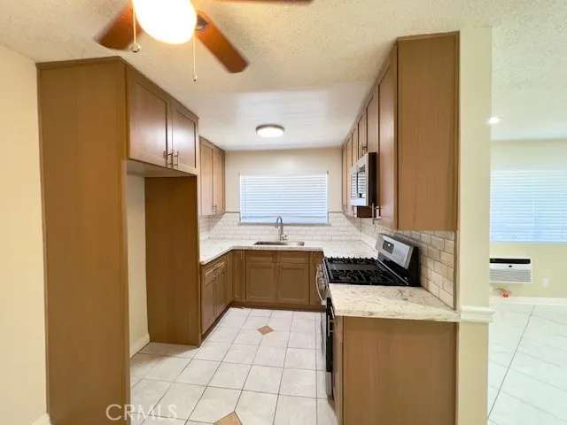 a kitchen with stainless steel appliances granite countertop a sink stove and microwave