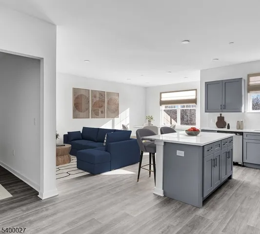 a living room with stainless steel appliances granite countertop a table and chairs