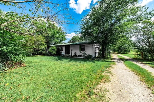 a view of a house with backyard and a tree