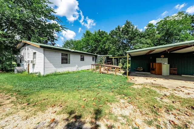 a front view of house with yard and trees around