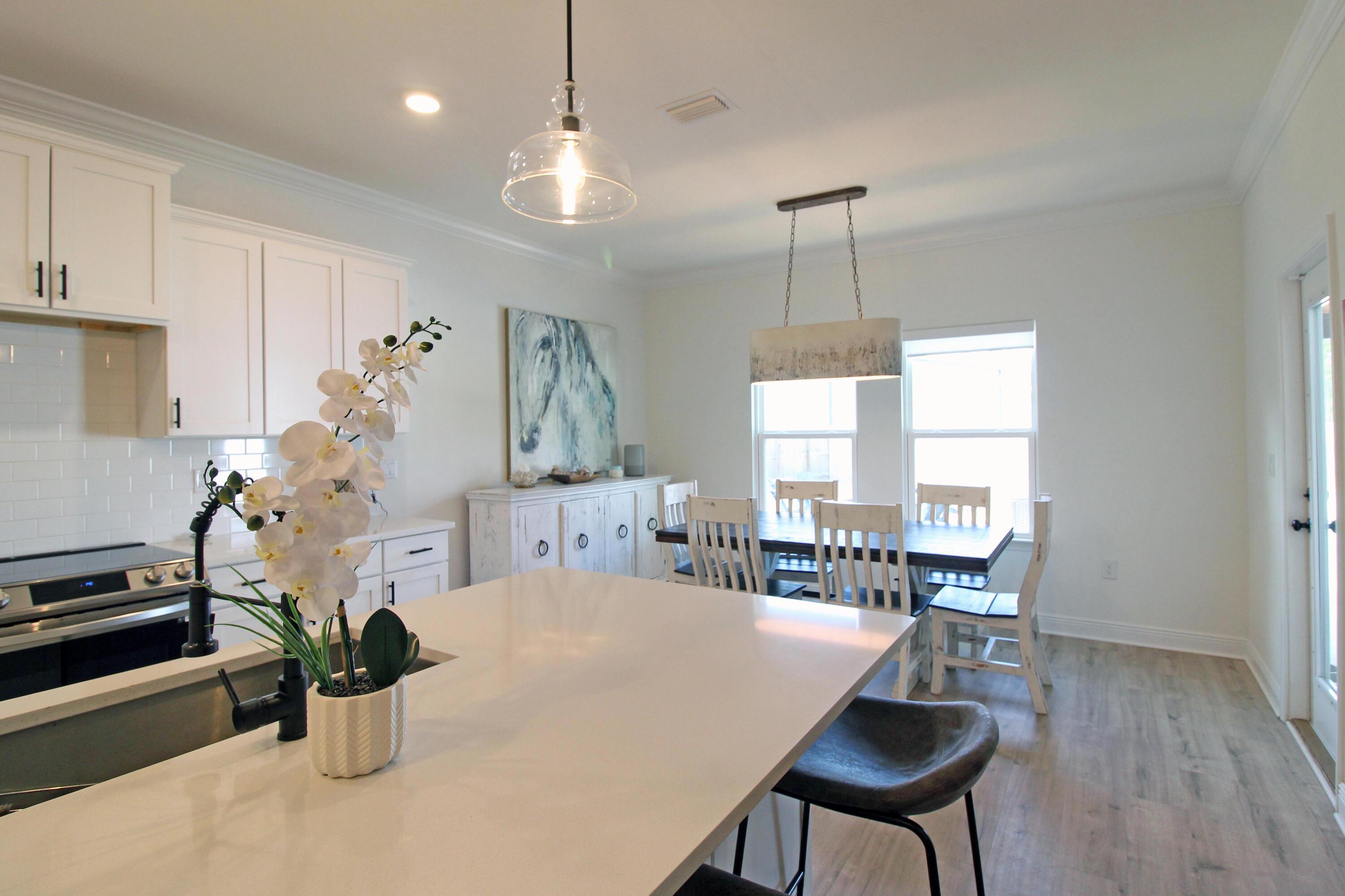 64 Indian Cove Freeport, FL 32439 - Photo 33 of 87 a dining room with furniture potted plants and wooden floor