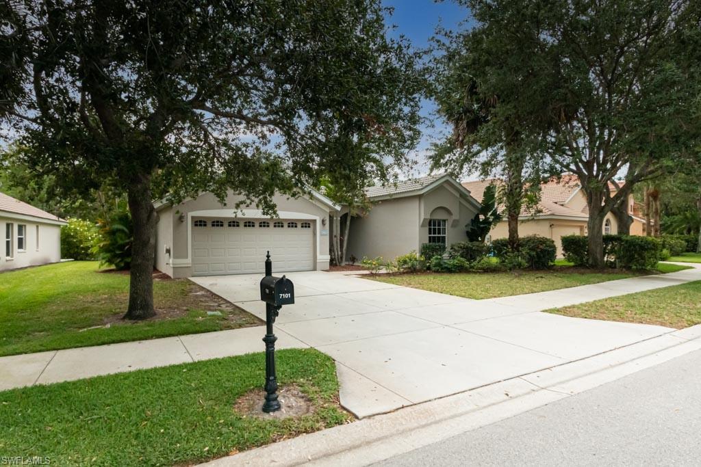 7101 Timberland Circle Naples, FL 34109 - Photo 2 of 50 a front view of a house with garden