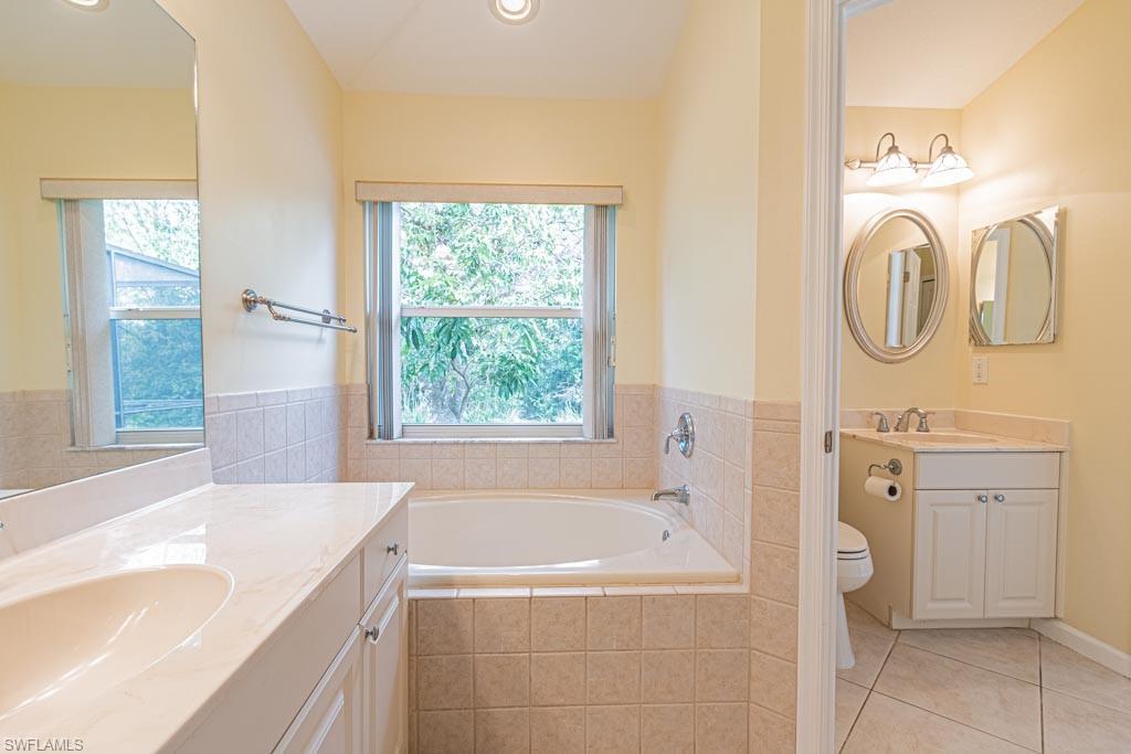 7101 Timberland Circle Naples, FL 34109 - Photo 26 of 50 a bathroom with a tub sink and mirror