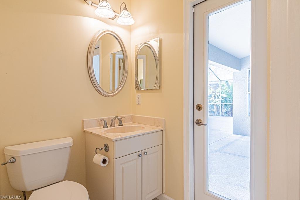 7101 Timberland Circle Naples, FL 34109 - Photo 28 of 50 a bathroom with a toilet sink and mirror