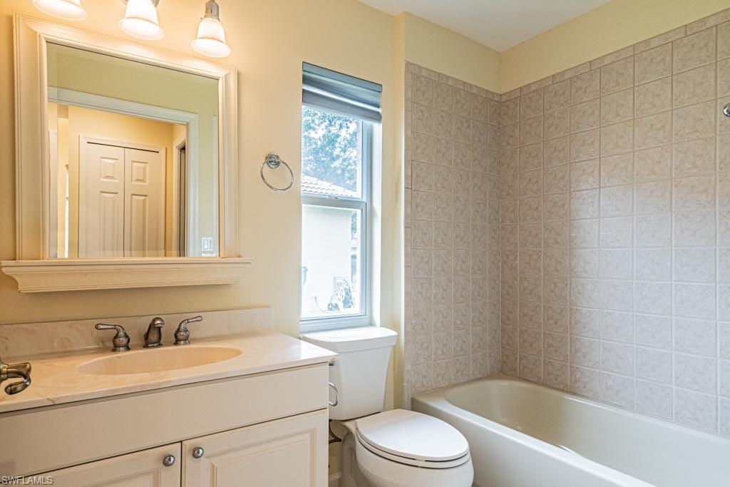 7101 Timberland Circle Naples, FL 34109 - Photo 34 of 50 a bathroom with a granite countertop sink toilet a mirror and bathtub