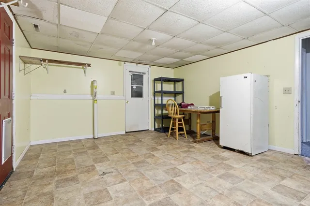 an empty room with windows & cabinet