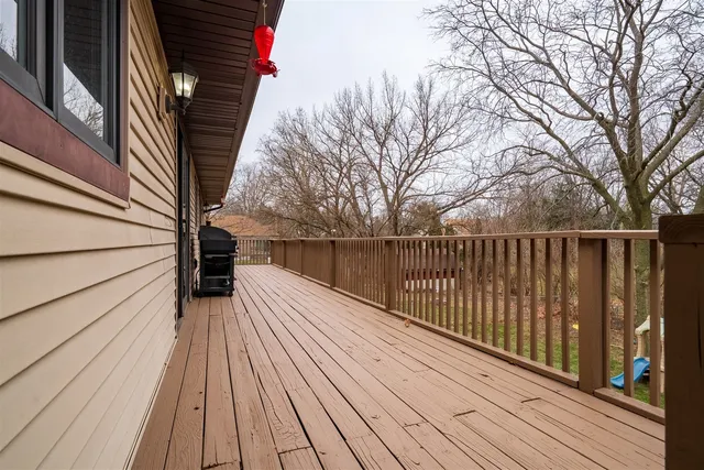 a view of a roof deck with table and chairs under an umbrella
