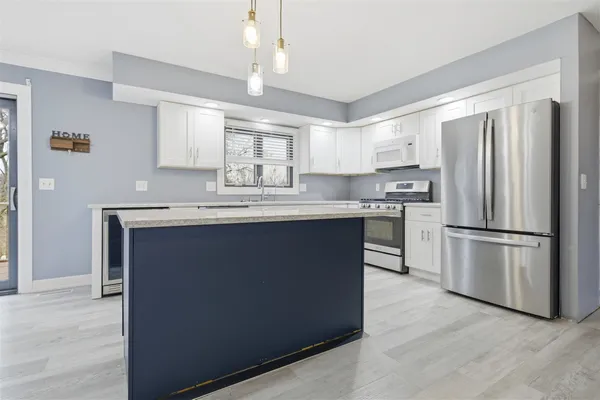 a kitchen with kitchen island a counter top space stainless steel appliances and cabinets