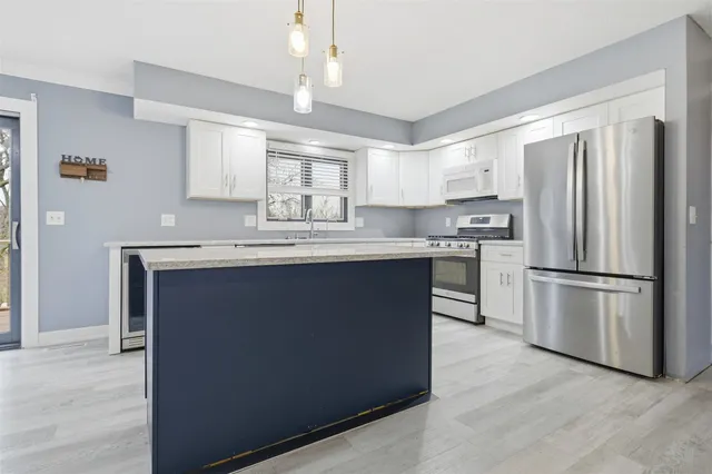 a kitchen with kitchen island a counter top space stainless steel appliances and cabinets