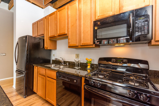 1500 West Monroe Street, Unit 715 Chicago, IL 60607 - Photo 3 of 26 a kitchen with stainless steel appliances granite countertop a stove a sink and a microwave