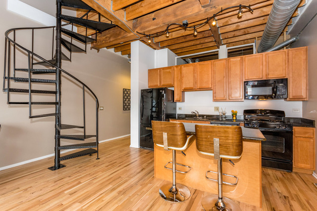 1500 West Monroe Street, Unit 715 Chicago, IL 60607 - Photo 4 of 26 a view of a kitchen with wooden floor and electronic appliances