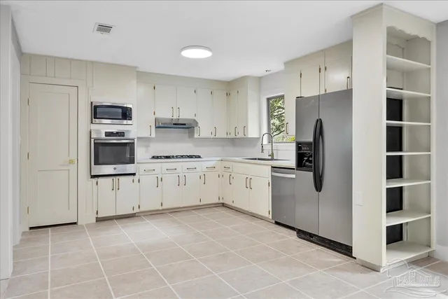a kitchen with stainless steel appliances a refrigerator sink and cabinets