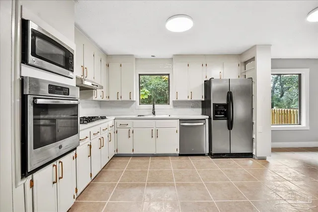 a kitchen with stainless steel appliances granite countertop a refrigerator stove microwave and sink