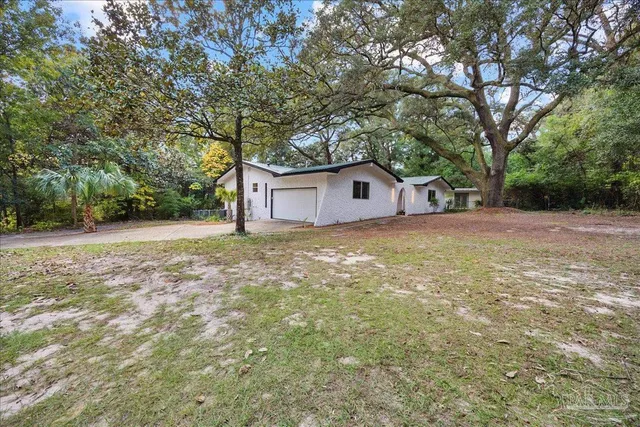 a view of a house with a yard and tree