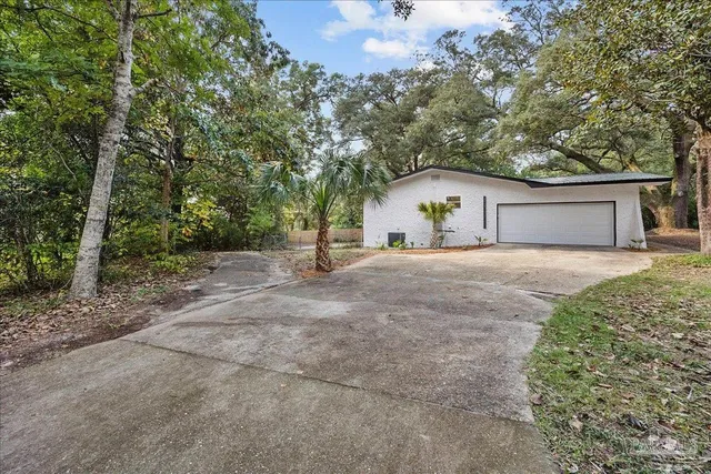 a view of a house with a yard and large tree