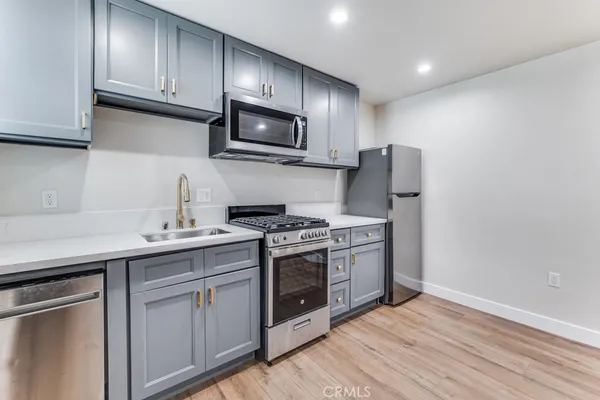 a kitchen with stainless steel appliances granite countertop a sink stove and microwave
