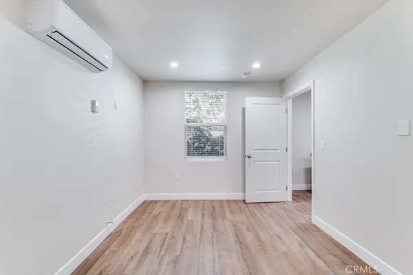 a view of empty room with wooden floor