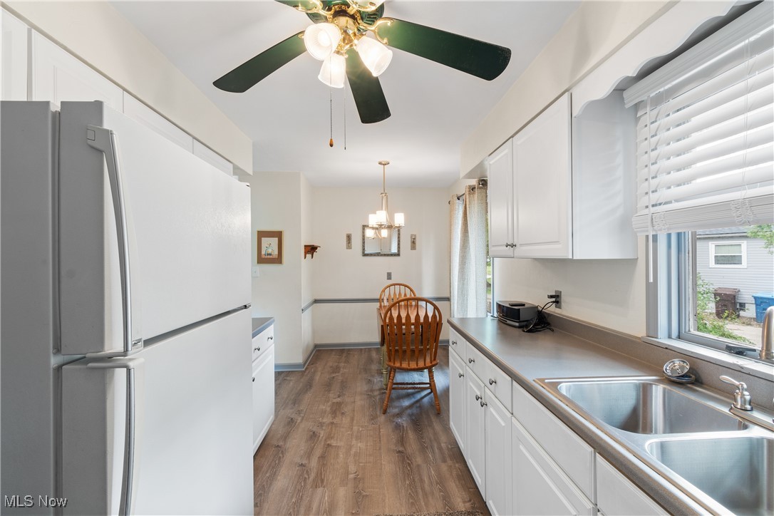 1067 Munroe Falls Kent Road Kent, OH 44240 - Photo 11 of 31 Kitchen with white cabinetry, white refrigerator, ceiling fan with notable chandelier, and hardwood / wood-style floors