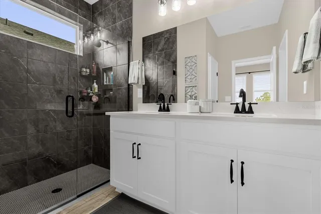 a bathroom with a shower sink and mirror