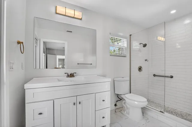 a bathroom with a sink a toilet and shower
