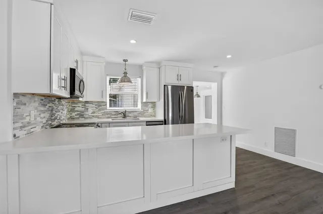 a kitchen with stainless steel appliances granite countertop a refrigerator and a sink