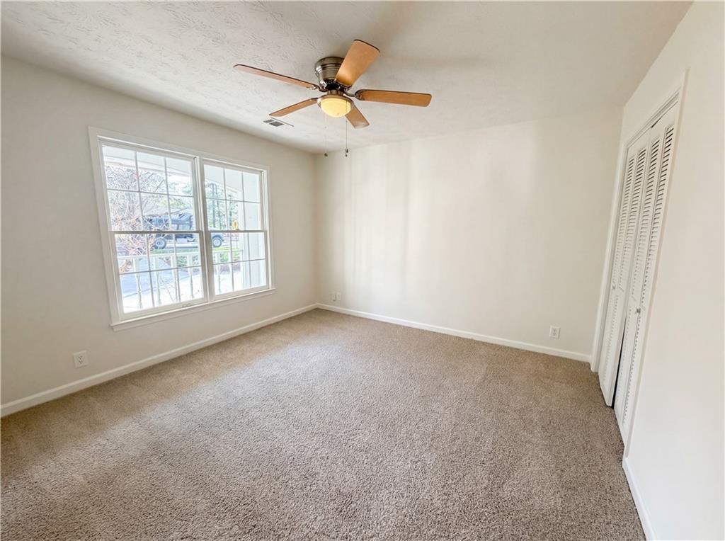 197 Rockbridge Road Southwest Lilburn, GA 30047 - Photo 16 of 27 an empty room with windows and fan