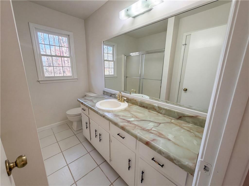 197 Rockbridge Road Southwest Lilburn, GA 30047 - Photo 21 of 27 a bathroom with a granite countertop sink two mirror and a shower