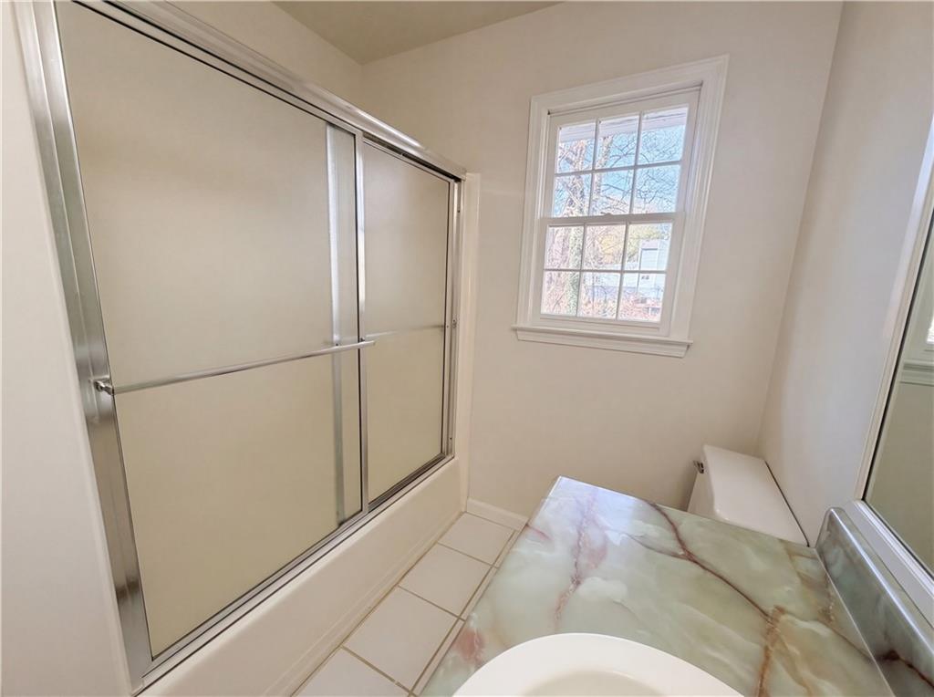 197 Rockbridge Road Southwest Lilburn, GA 30047 - Photo 22 of 27 a bathroom with a bathtub and a shower