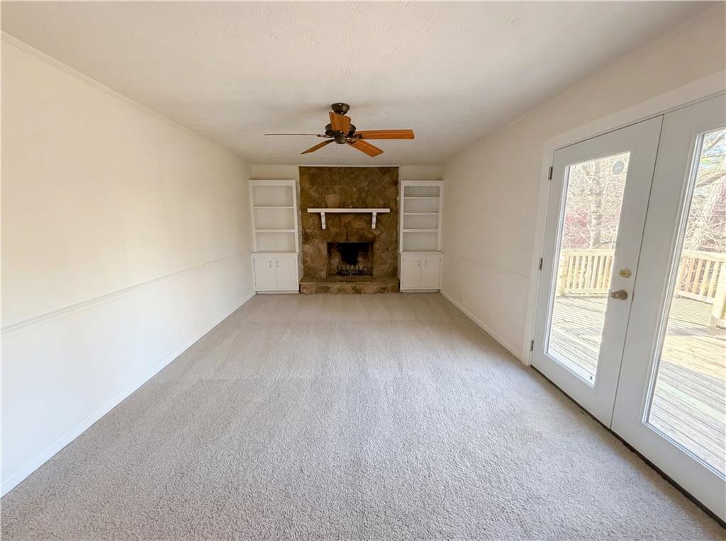 197 Rockbridge Road Southwest Lilburn, GA 30047 - Photo 4 of 27 an empty room with windows and fireplace