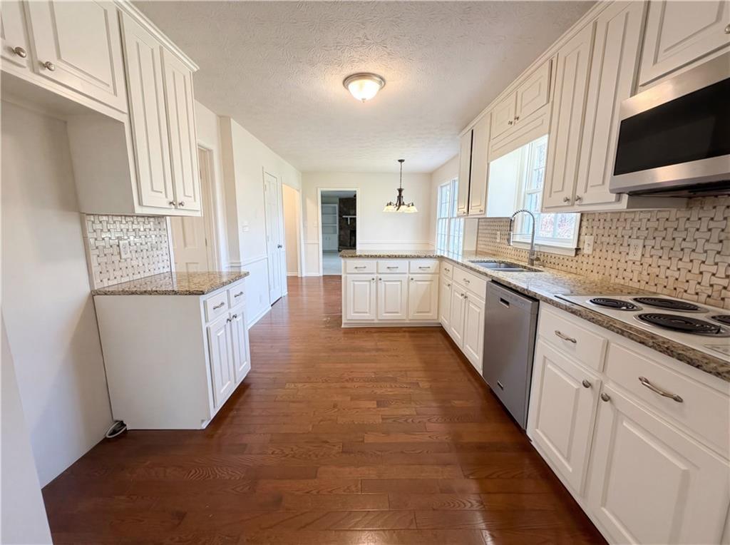 197 Rockbridge Road Southwest Lilburn, GA 30047 - Photo 7 of 27 a large kitchen with cabinets stove top oven a sink and dishwasher