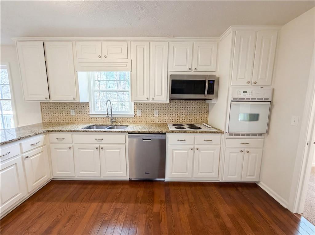 197 Rockbridge Road Southwest Lilburn, GA 30047 - Photo 9 of 27 a kitchen with granite countertop white cabinets white stainless steel appliances and sink