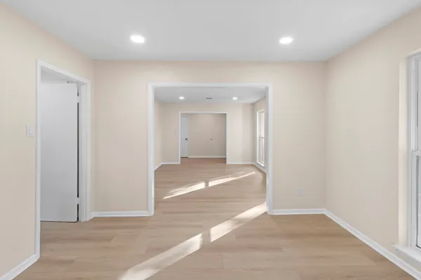 an empty room with wooden floor and bathroom
