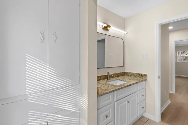 a bathroom with a granite countertop sink and a mirror