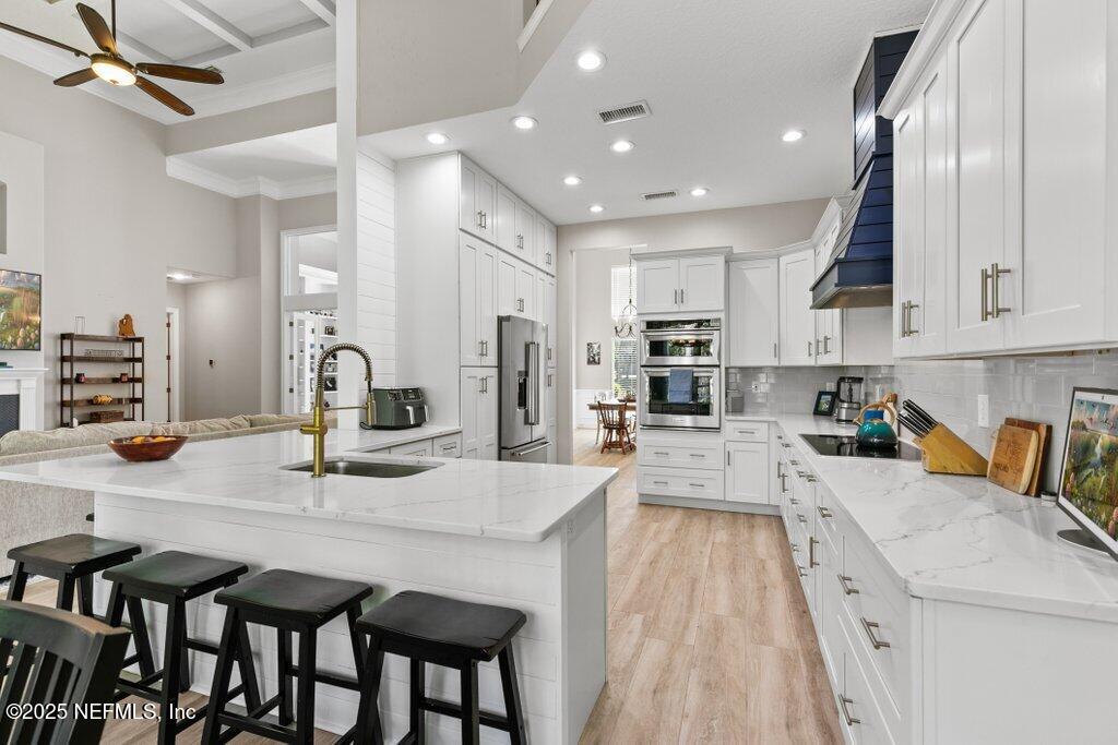 2676 Country Side Drive Fleming Island, FL 32003 - Photo 23 of 125 a kitchen with stainless steel appliances granite countertop a table chairs sink and cabinets